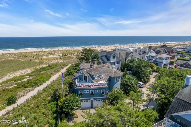 an aerial view of ocean and residential houses with outdoor space