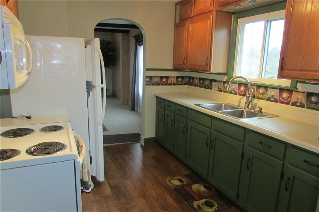 3110 Mercer Road New Castle, PA 16105 - Photo 8 of 25 Galley Kitchen with appliances. Newer kitchen faucet and newer laminated floors.
