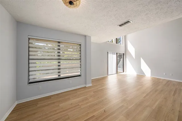 a view of a livingroom with wooden floor and a large window
