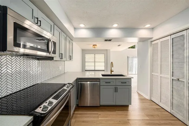 a kitchen with stainless steel appliances granite countertop a stove a sink and a microwave