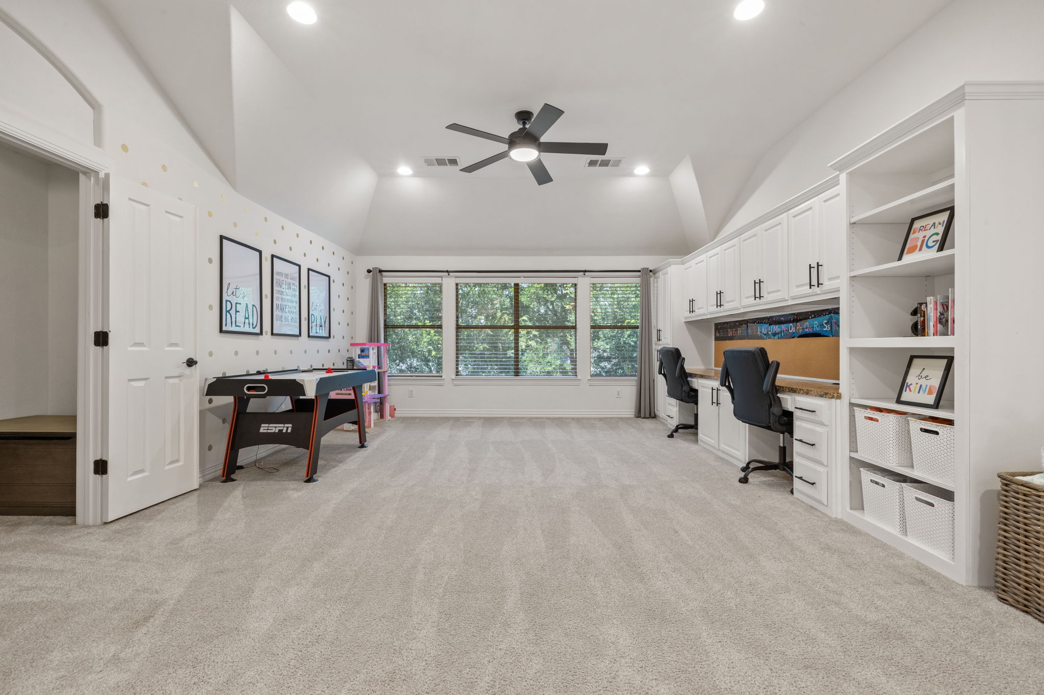 1124 Castle Path Round Rock, TX 78681 - Photo 24 of 40 A spacious recreation area with ample natural light, featuring built-in desks and shelving, ideal for work and play.