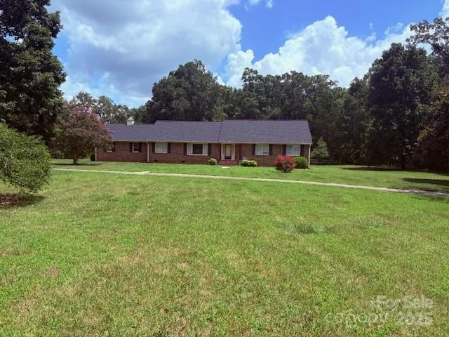a view of a big room with a big yard and large trees