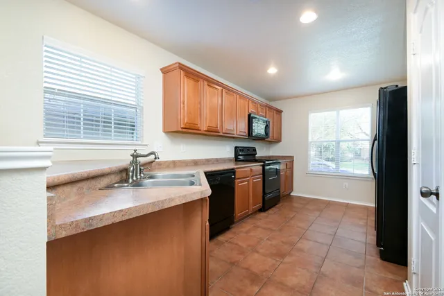 a kitchen with a sink window and cabinets