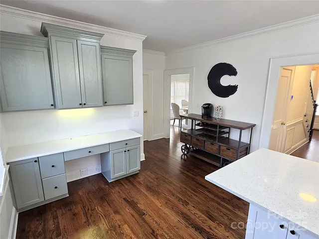 a kitchen with a wooden floor and cabinets