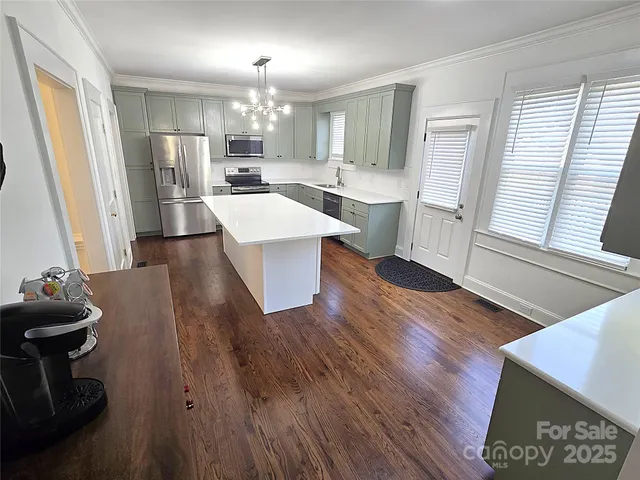 a living room with kitchen island granite countertop wooden floor and a fireplace