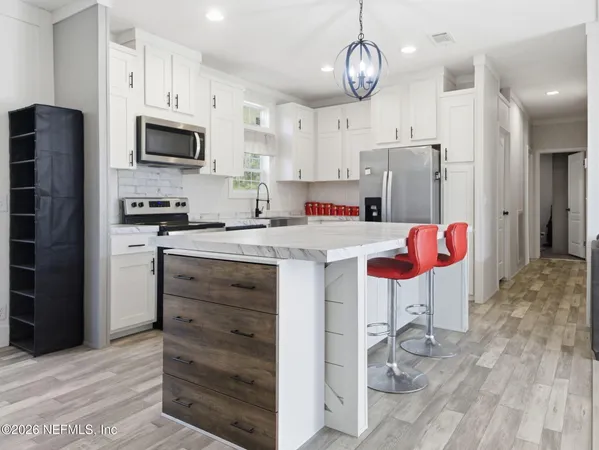 a kitchen with stainless steel appliances kitchen island granite countertop a refrigerator and a stove top oven