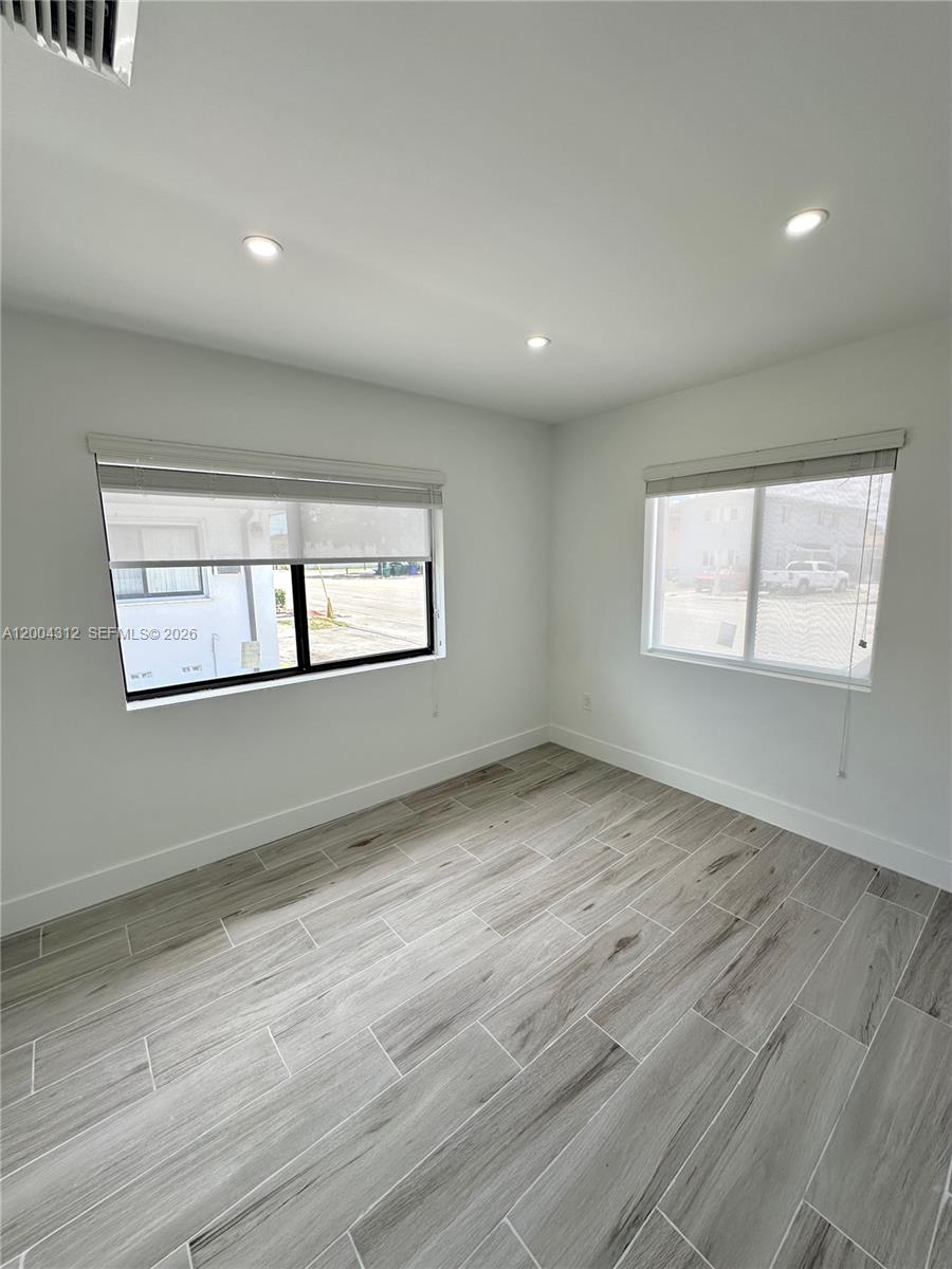 551 Southwest 57th Avenue, Unit 1 Miami, FL 33144 - Photo 18 of 24 a view of an empty room with wooden floor and a window