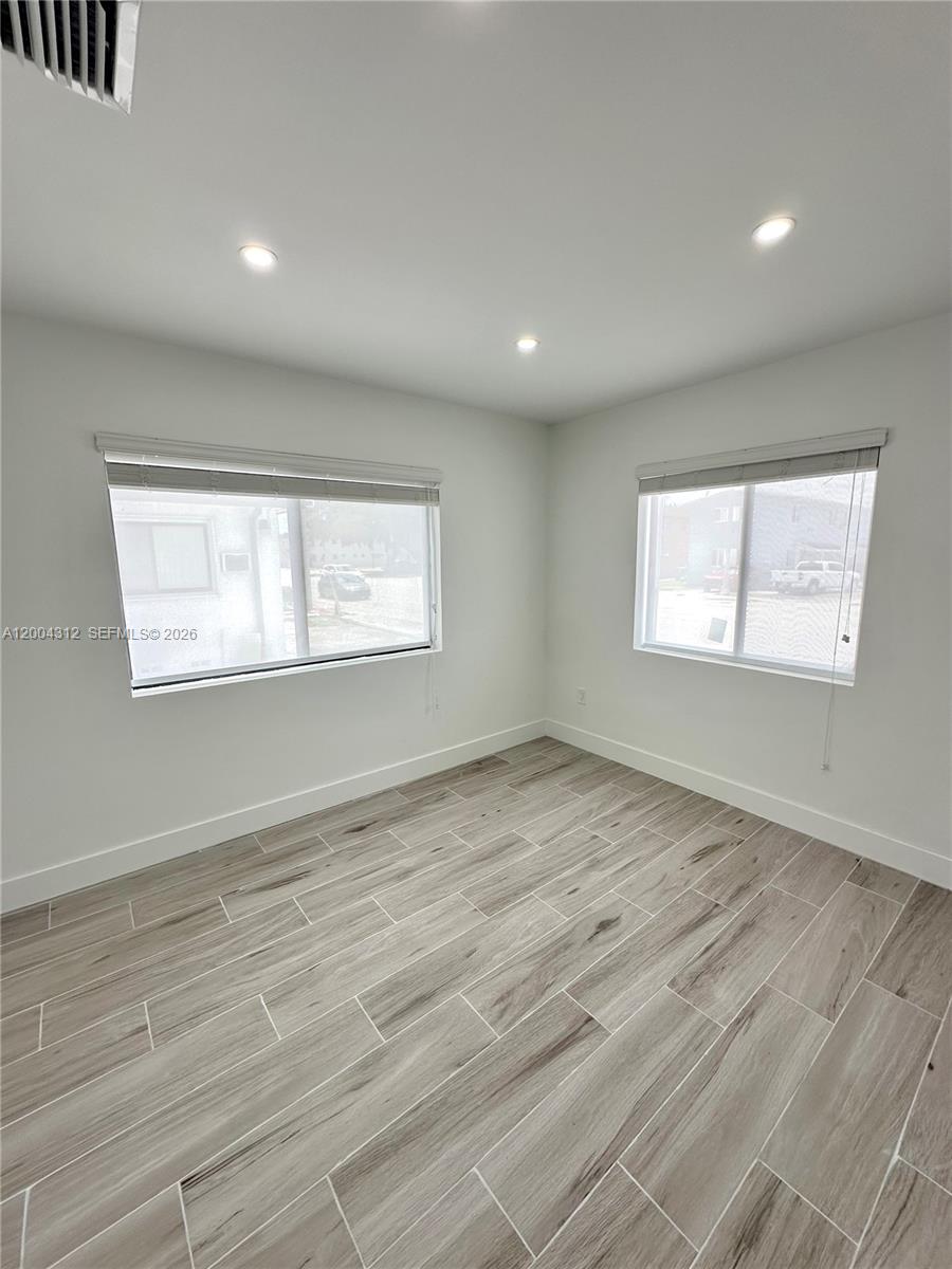 551 Southwest 57th Avenue, Unit 1 Miami, FL 33144 - Photo 19 of 24 a view of an empty room with wooden floor and a window