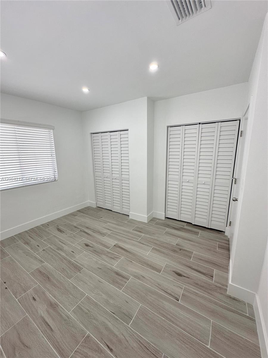 551 Southwest 57th Avenue, Unit 1 Miami, FL 33144 - Photo 21 of 24 an empty room with wooden floor and windows