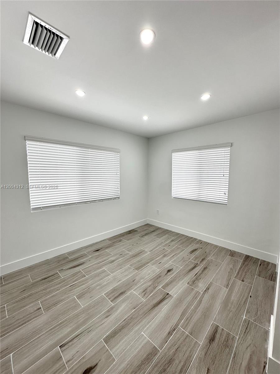 551 Southwest 57th Avenue, Unit 1 Miami, FL 33144 - Photo 22 of 24 an empty room with wooden floor and windows