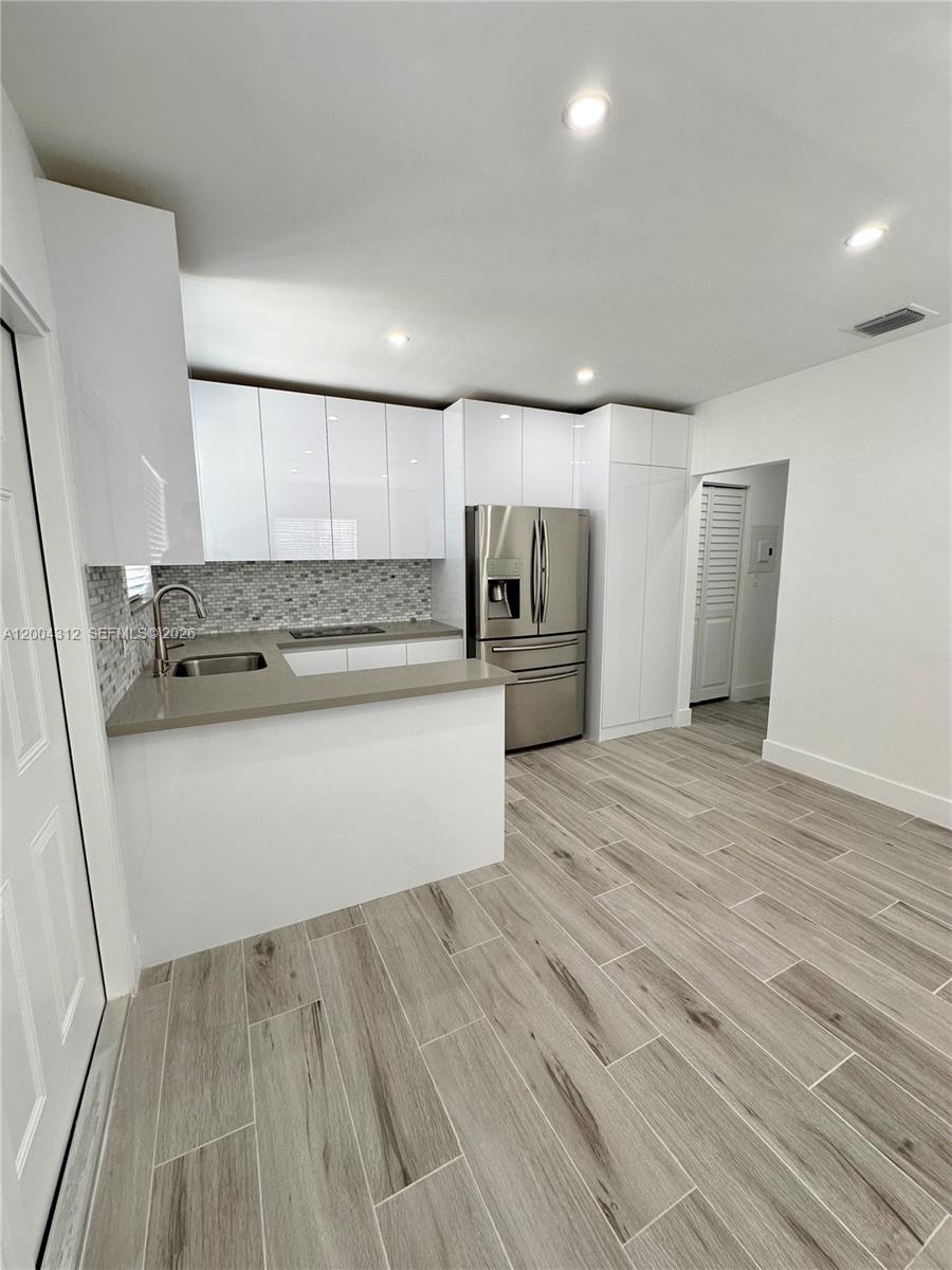 551 Southwest 57th Avenue, Unit 1 Miami, FL 33144 - Photo 3 of 24 a view of kitchen with refrigerator and wooden floor