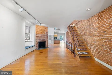 a view of a livingroom with wooden floor and a fireplace