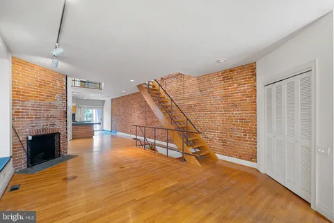 a view of empty room with wooden floor and fireplace