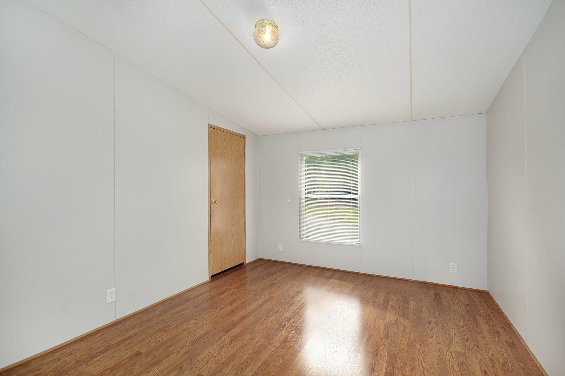 8144 Mt Pleasant Church Road Willow Spring, NC 27592 - Photo 18 of 25 an empty room with wooden floor and windows