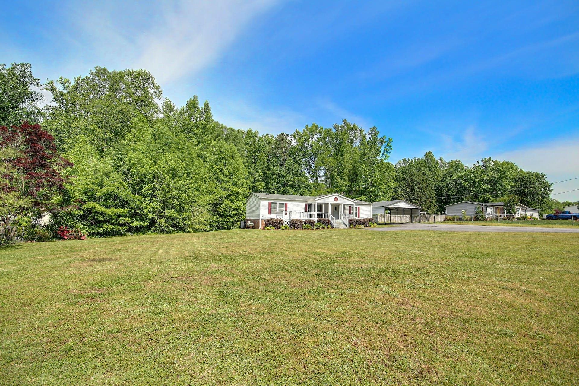 8144 Mt Pleasant Church Road Willow Spring, NC 27592 - Photo 3 of 25 a white house with a big yard and large trees