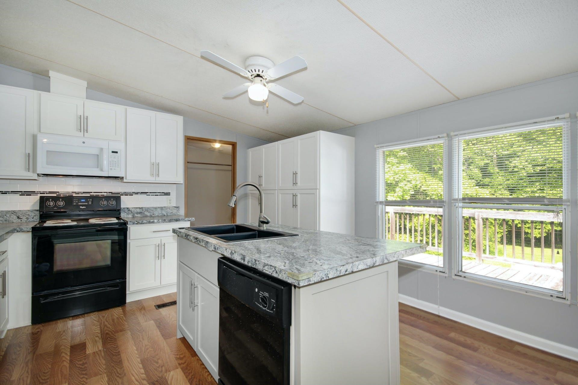 8144 Mt Pleasant Church Road Willow Spring, NC 27592 - Photo 10 of 25 a kitchen with granite countertop stainless steel appliances a stove cabinets and wooden floor