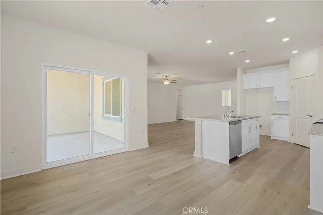 a view of a kitchen with white cabinets and wooden floor