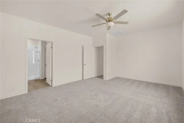 an empty room with closet and windows