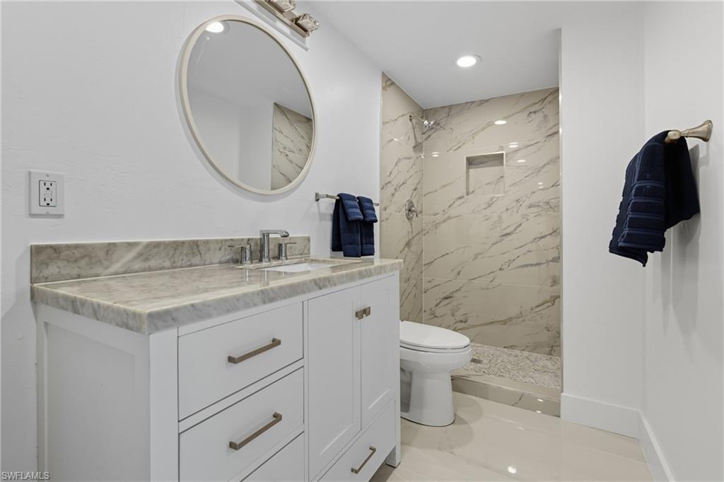 1280 Pine Street Naples, FL 34104 - Photo 13 of 36 a bathroom with a granite countertop sink toilet and a mirror