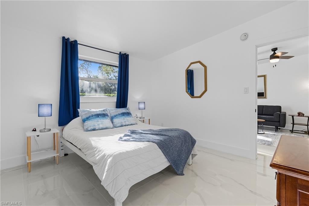1280 Pine Street Naples, FL 34104 - Photo 14 of 36 a bedroom with a bed and a flat screen tv