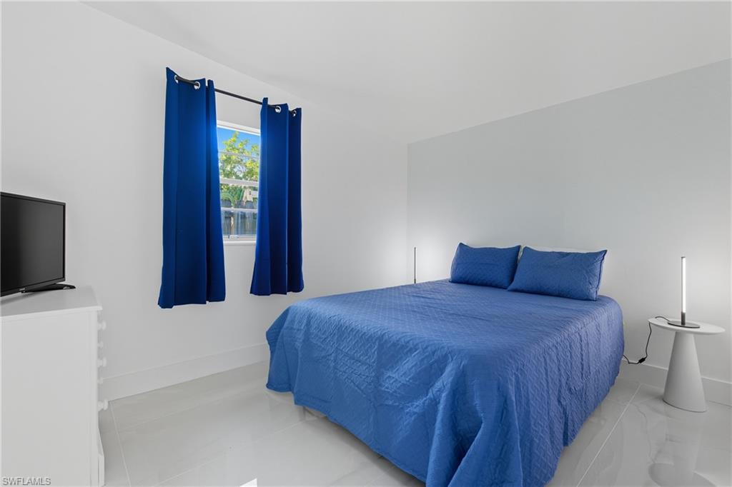 1280 Pine Street Naples, FL 34104 - Photo 15 of 36 a bedroom with a bed and a flat screen tv