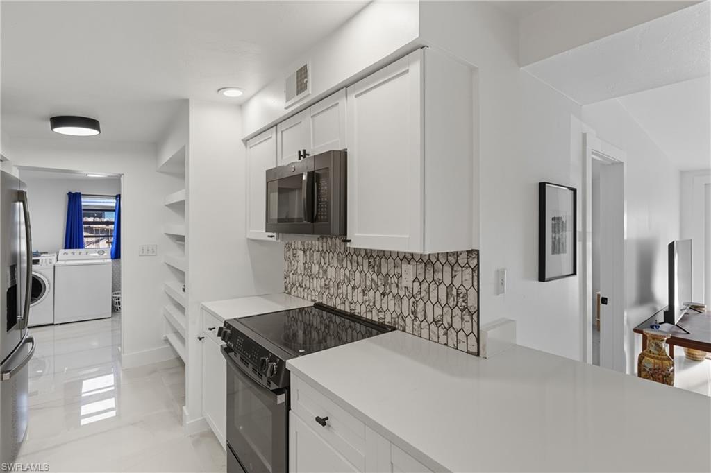 1280 Pine Street Naples, FL 34104 - Photo 24 of 36 a kitchen with stainless steel appliances a stove microwave and refrigerator