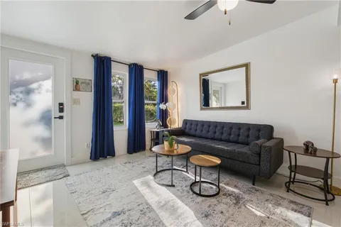 a living room with furniture and a painting on the wall