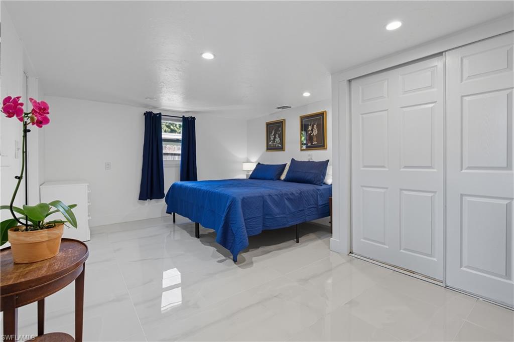 1280 Pine Street Naples, FL 34104 - Photo 7 of 36 a bedroom with a bed and a potted plant