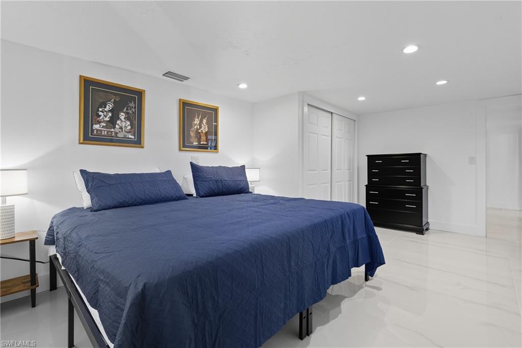 1280 Pine Street Naples, FL 34104 - Photo 8 of 36 a bedroom with a bed and a walk in closet