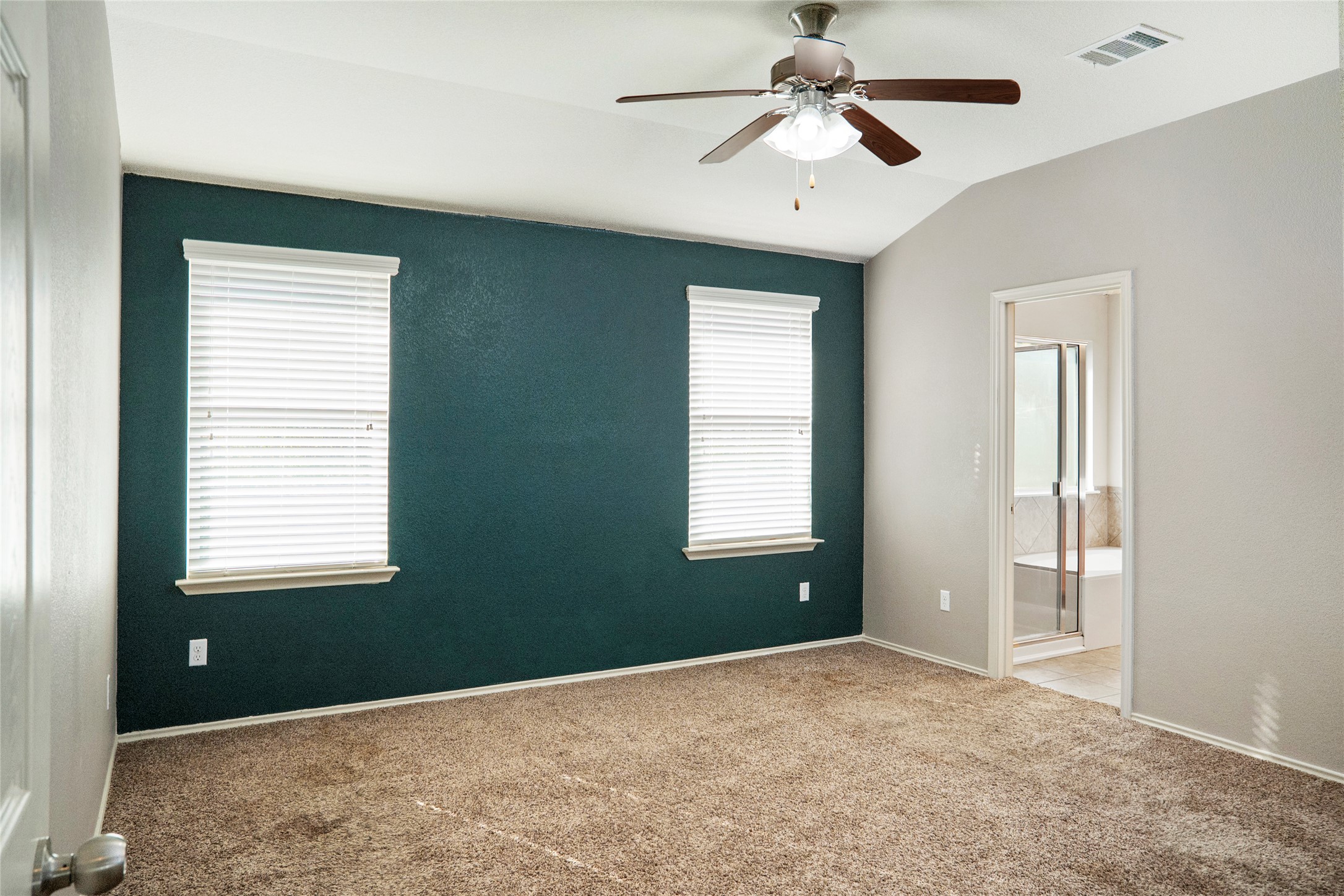 212 Foster Lane Jarrell, TX 76537 - Photo 20 of 22 Spacious room featuring vaulted ceilings with textured walls, and windows bring in natural light while over looking the backyard