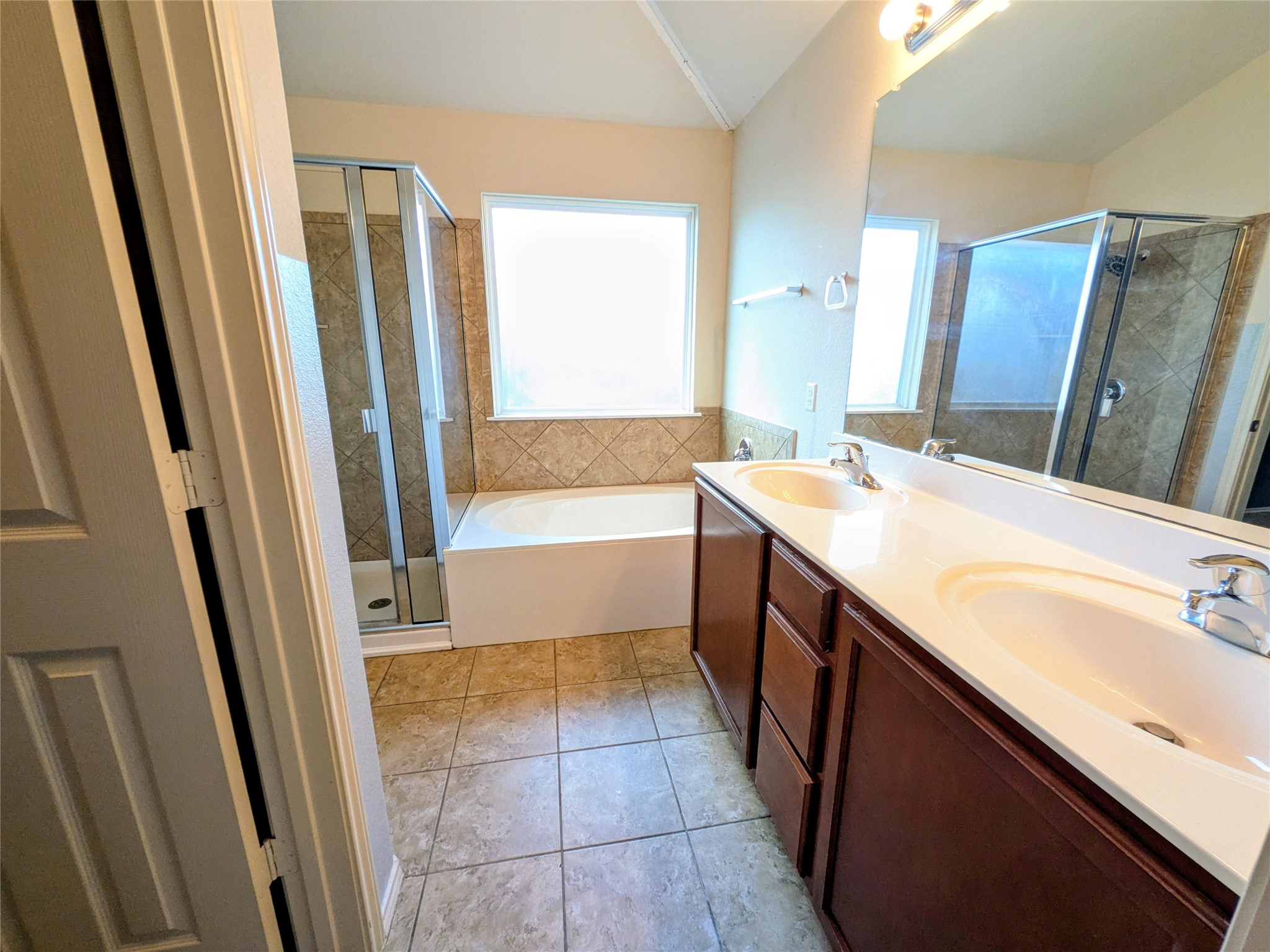 212 Foster Lane Jarrell, TX 76537 - Photo 21 of 22 Bathroom featuring a double vanity with wood cabinetry and white countertops, a soaking tub, a walk-in shower with glass enclosure, and tiled flooring