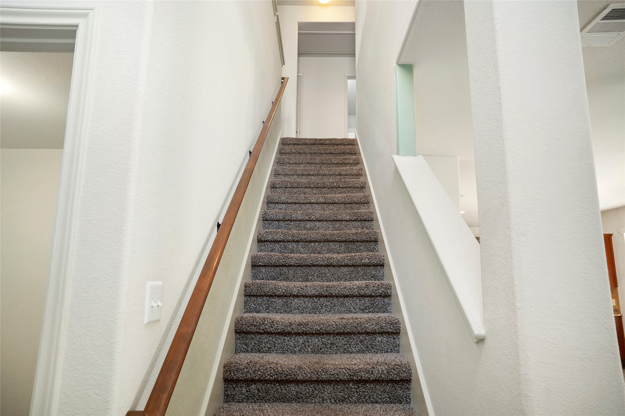 212 Foster Lane Jarrell, TX 76537 - Photo 10 of 22 Carpeted staircase with a wood handrail