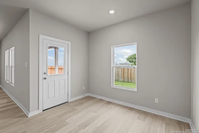 an empty room with wooden floor and a window
