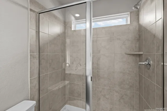 a bathroom with a glass shower door