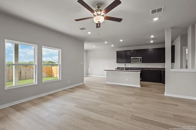 a view of kitchen with kitchen island a stove a sink and a microwave