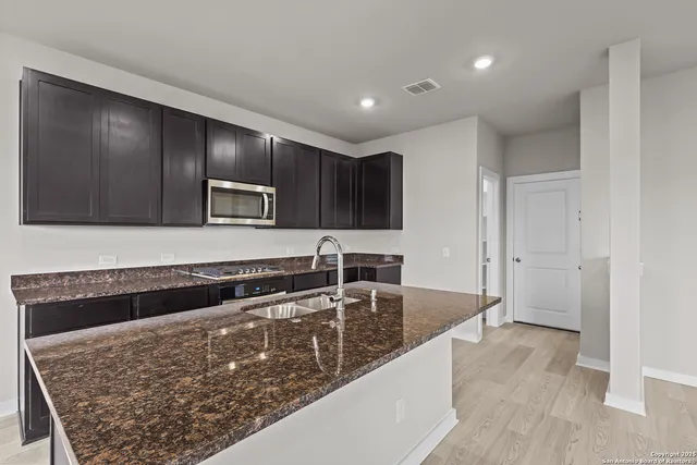 a kitchen with stainless steel appliances granite countertop a sink and a stove