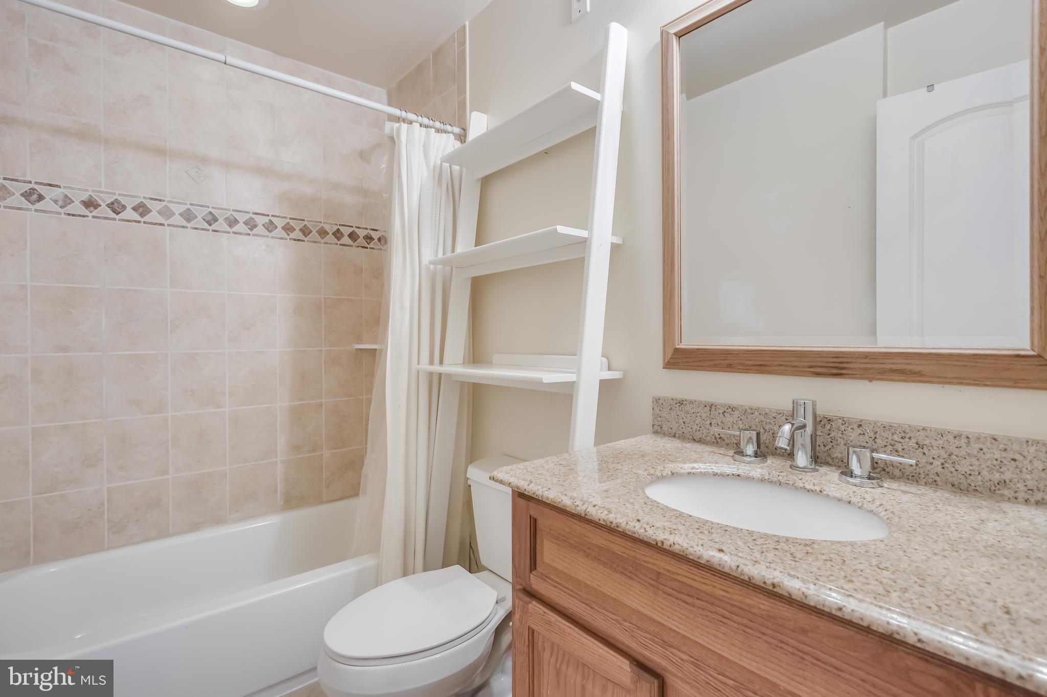2307 18th Street Northwest, Unit 1 Washington, DC 20009 - Photo 16 of 21 a bathroom with a granite countertop sink toilet and shower