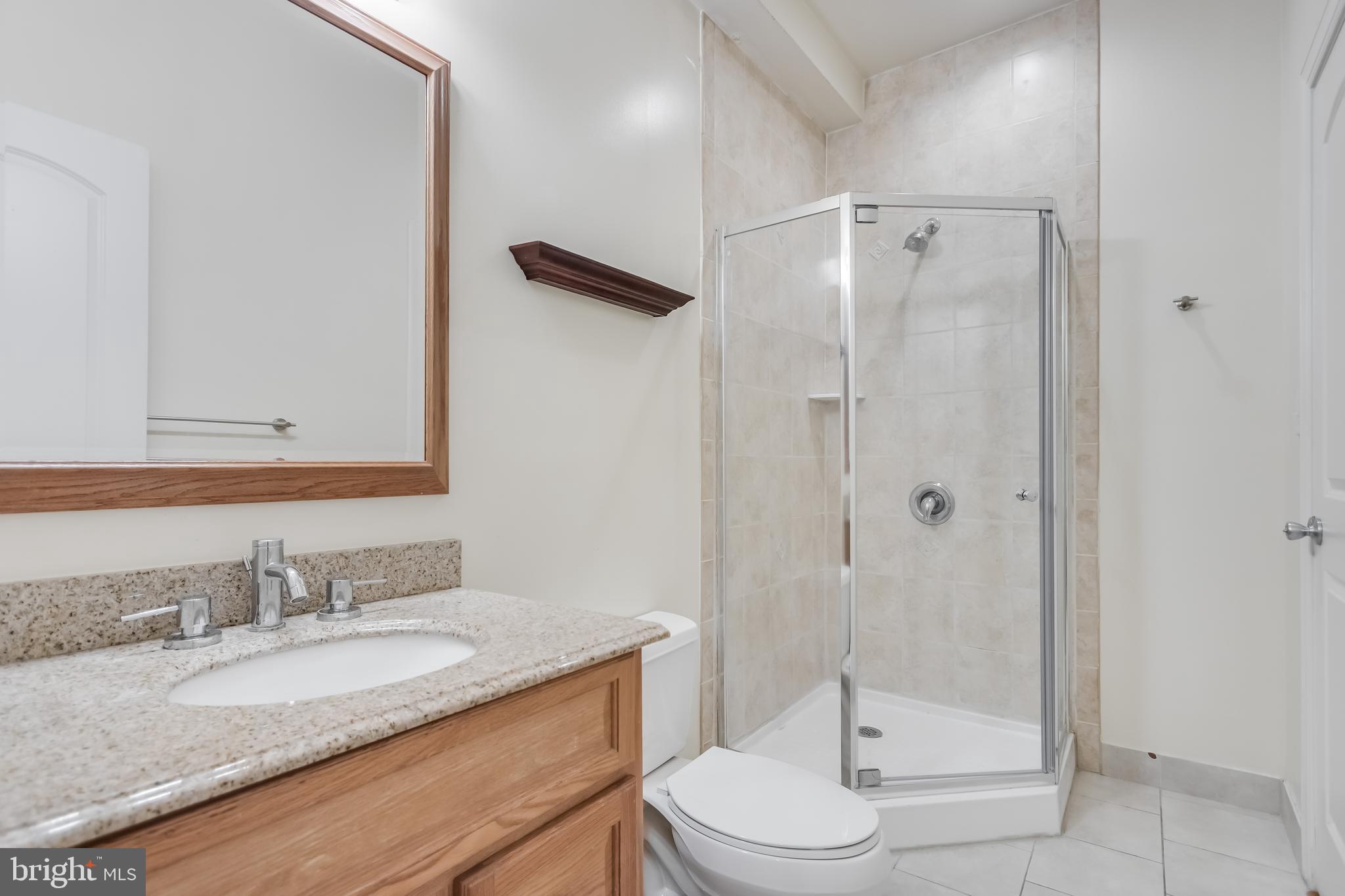 2307 18th Street Northwest, Unit 1 Washington, DC 20009 - Photo 20 of 21 a bathroom with a granite countertop sink toilet a mirror and shower