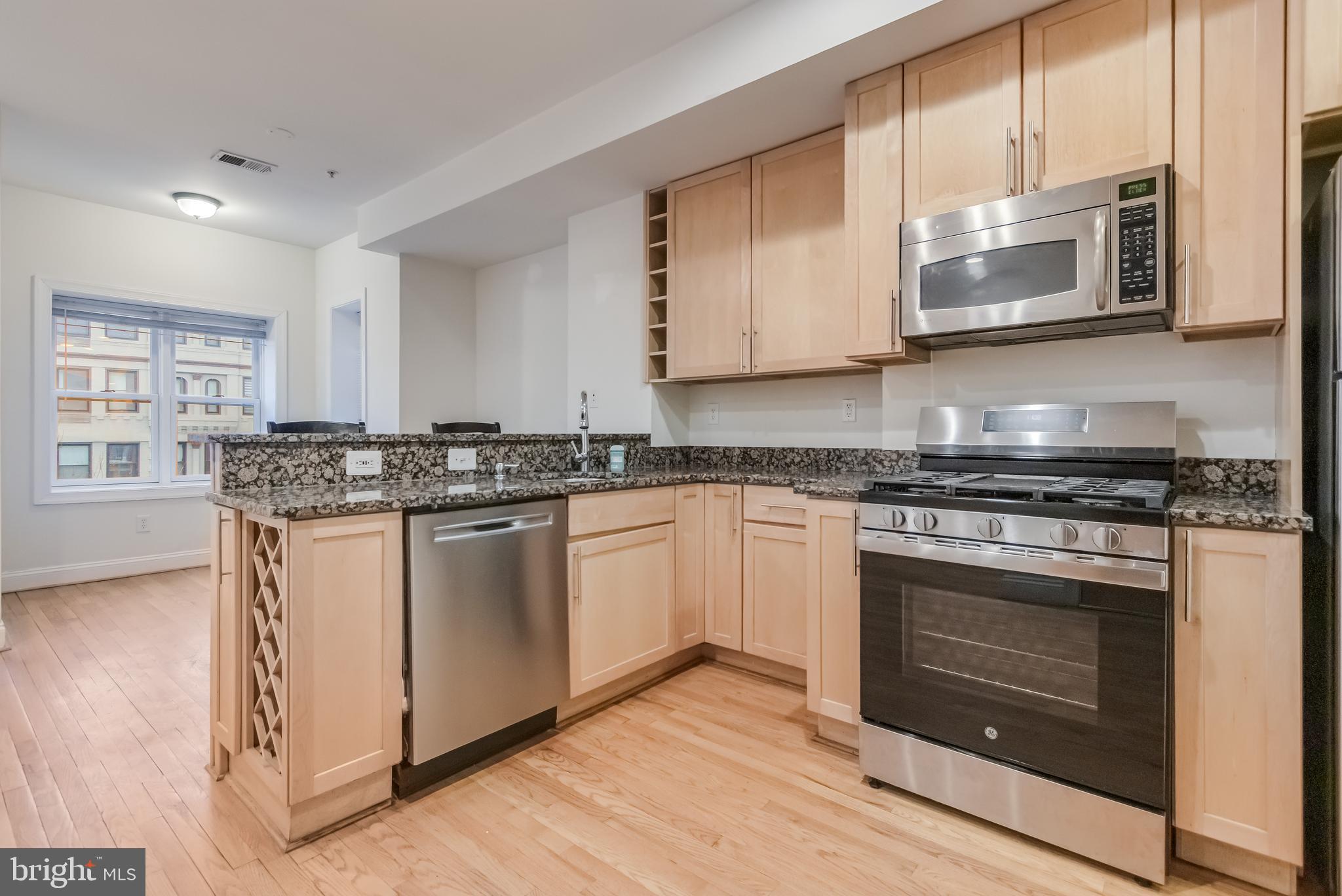 2307 18th Street Northwest, Unit 1 Washington, DC 20009 - Photo 3 of 21 a kitchen with stainless steel appliances granite countertop a stove a sink and a microwave