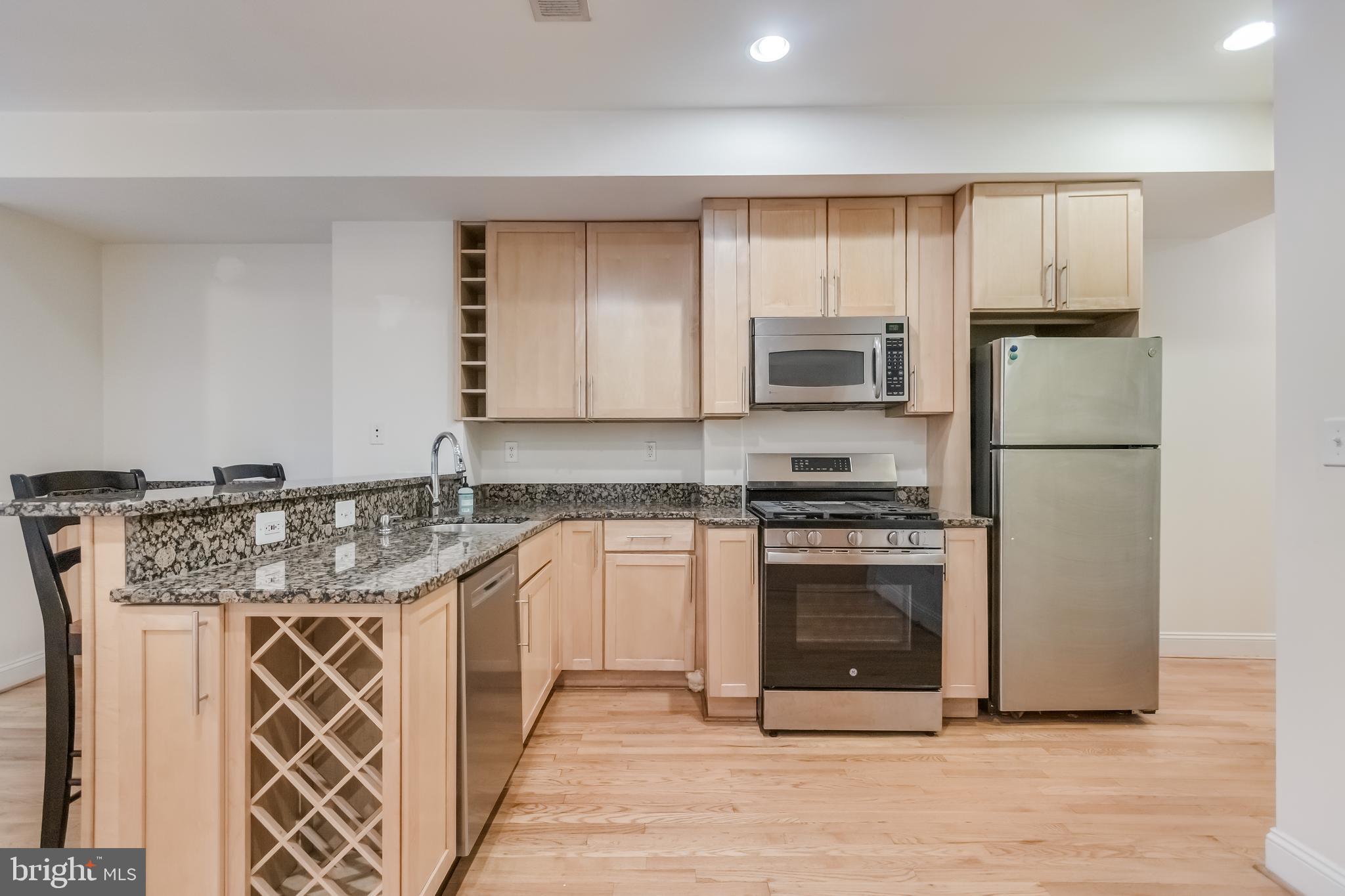 2307 18th Street Northwest, Unit 1 Washington, DC 20009 - Photo 4 of 21 a kitchen with stainless steel appliances granite countertop a stove a sink and a refrigerator