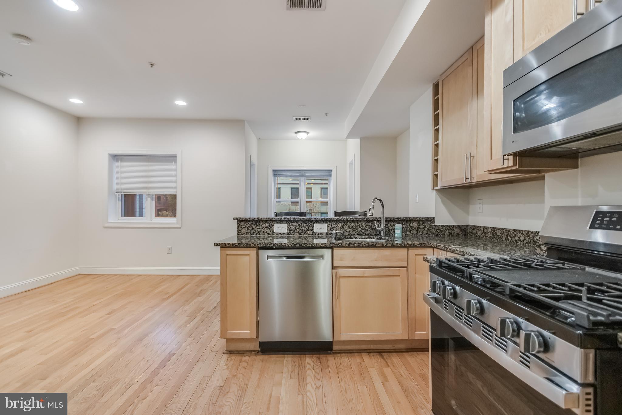 2307 18th Street Northwest, Unit 1 Washington, DC 20009 - Photo 5 of 21 a kitchen with stainless steel appliances granite countertop a stove and a wooden floors