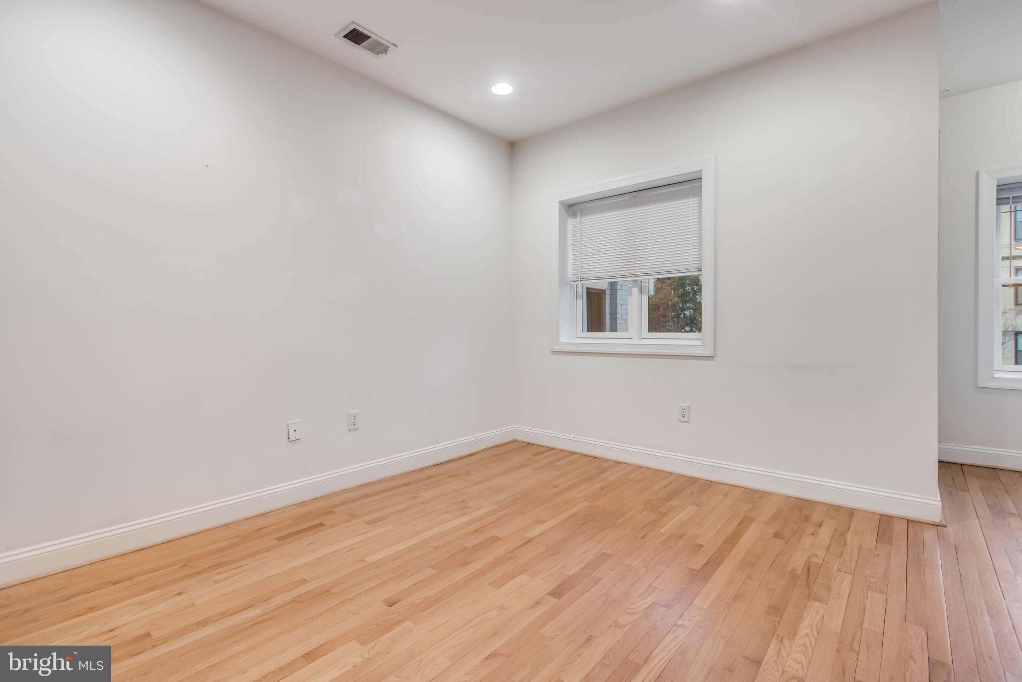 2307 18th Street Northwest, Unit 1 Washington, DC 20009 - Photo 10 of 21 an empty room with wooden floor and windows