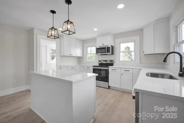 a kitchen with a refrigerator a microwave and cabinets