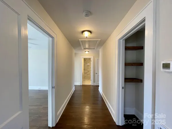 a view of a hallway with wooden shelves