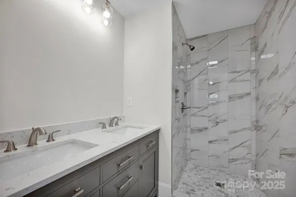 a bathroom with a granite countertop sink a toilet and shower