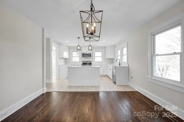 a view of a kitchen with wooden floor and a window