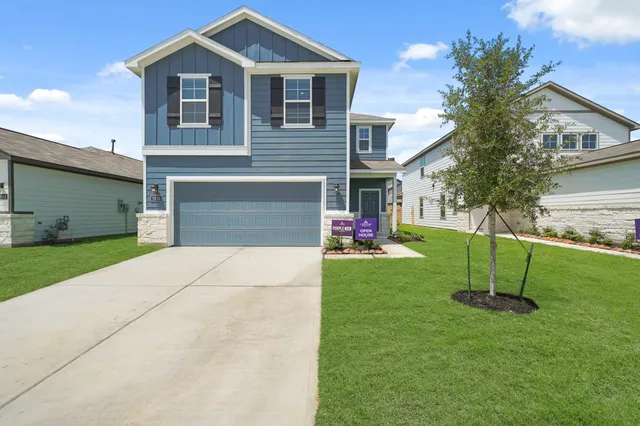 a front view of a house with a yard and a garage