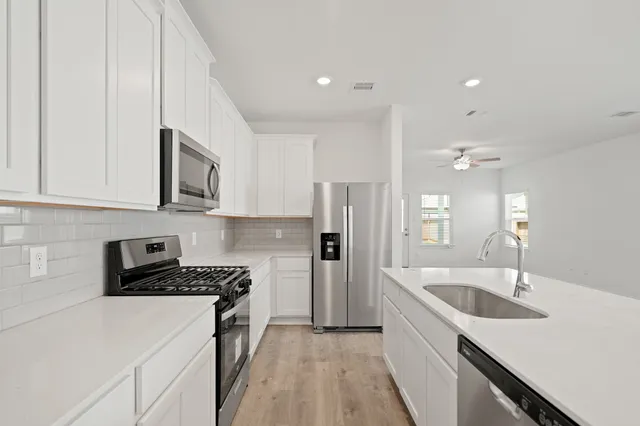 a kitchen with a sink stove top oven and refrigerator