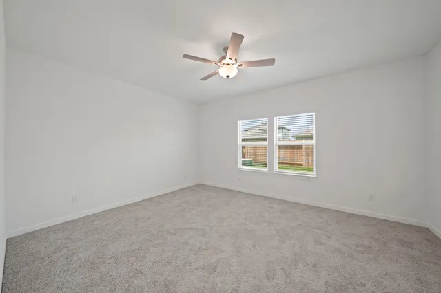 an empty room with a window and a ceiling fan