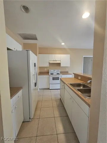 a kitchen with a stove a refrigerator and a sink